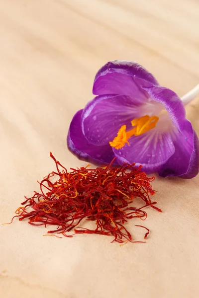 Beautiful purple crocus and saffron, on wooden background — Stock Photo, Image