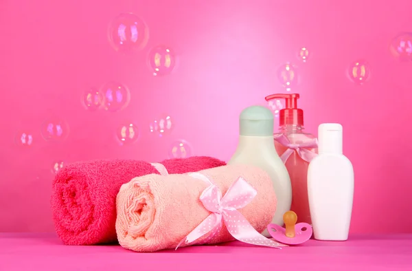 Dětské kosmetiky a ručníky na růžovém pozadí — Stock fotografie
