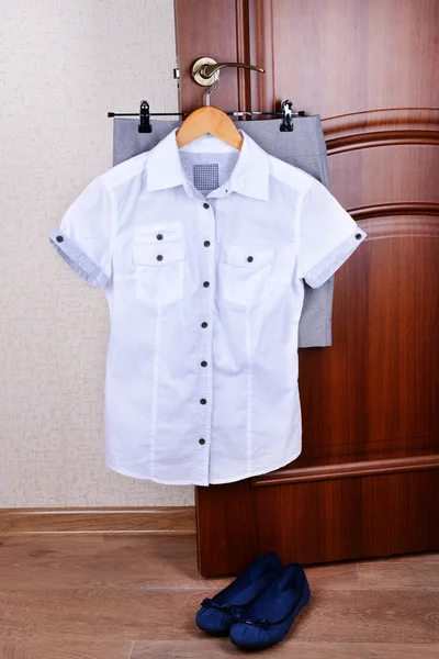 Blouse with skirt hanging on door — Stock Photo, Image