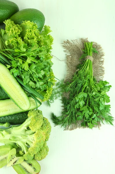 Fresh green vegetables and fruits, on color wooden background — Stock Photo, Image