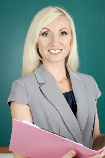 Lehrerin mit Mappe in der Nähe der Tafel in Großaufnahme — Stockfoto