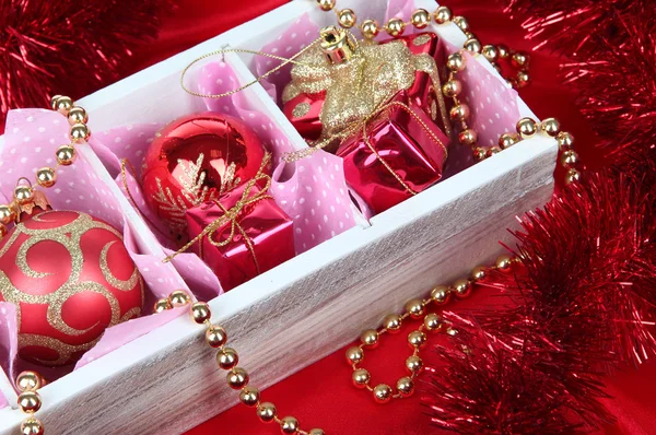 Різдвяні іграшки в дерев'яній коробці на яскравому фоні — стокове фото