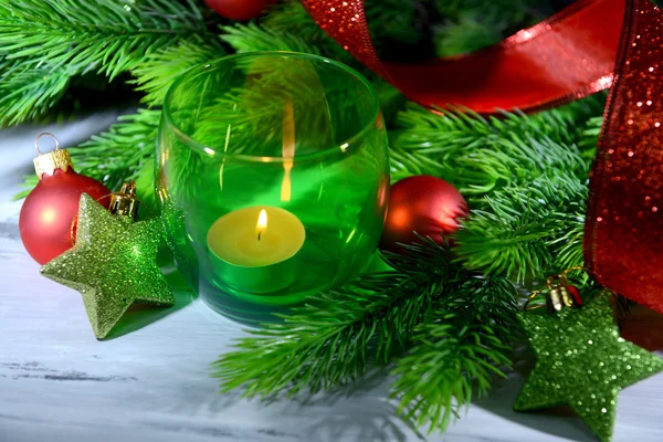 Composition with Christmas balls, candle and decorations on fir tree, close up — Stock Photo, Image