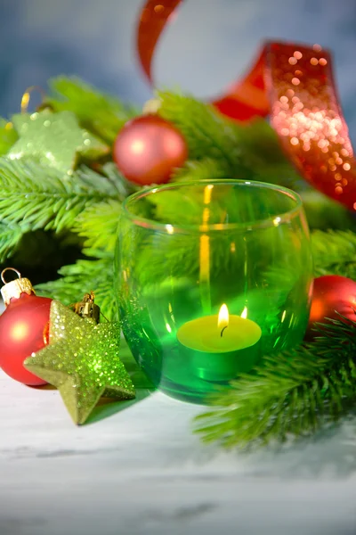 Composition with Christmas balls, candle and decorations on fir tree, close up — Stock Photo, Image
