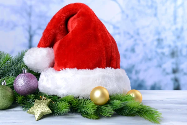 Kompozycja z santa claus czerwony kapelusz i świąteczne ozdoby na jasnym tle — Zdjęcie stockowe