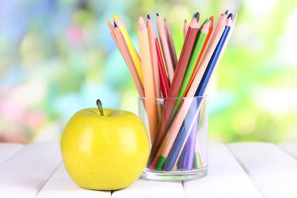 Colorful pencils in glass on wooden table on natural background — Stock Photo, Image