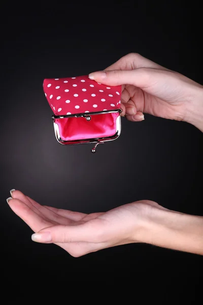 Mão feminina segurando bolsa rosa no fundo preto — Fotografia de Stock