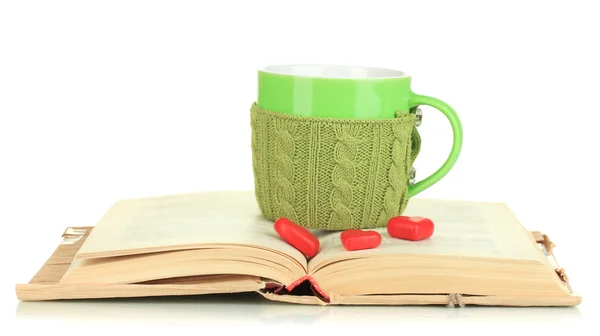 Cup with knitted thing on it and open book isolated on white — Stock Photo, Image