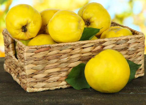 Quinces sucrés dans le panier en osier sur la table sur fond lumineux — Photo