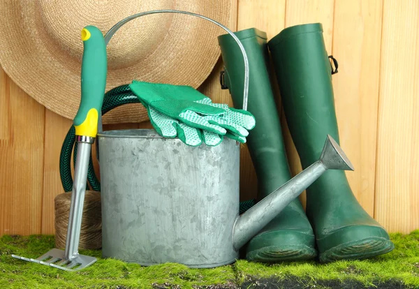 Gartengeräte auf Gras auf Holzgrund — Stockfoto