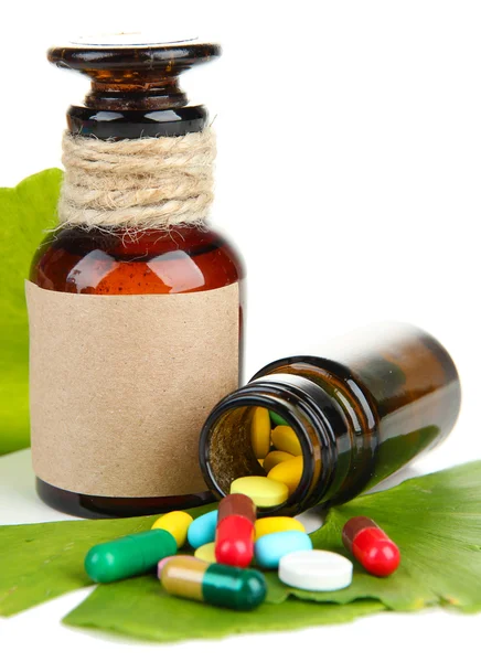 Ginkgo biloba foglie e flaconi di medicina con pillole isolate su bianco — Foto Stock