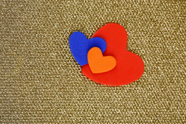 Hearts made of felt on golden background — Stock Photo, Image