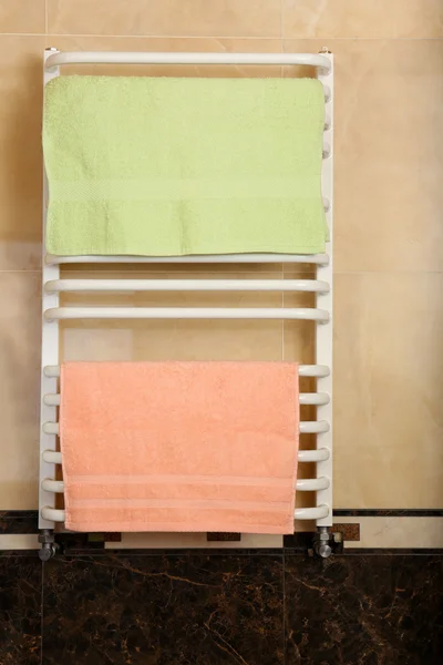 Color towels on radiator in bathroom — Stock Photo, Image