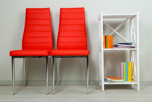 Mooi interieur met moderne kleur stoelen, boeken op houten voet, op de muur achtergrond — Stockfoto
