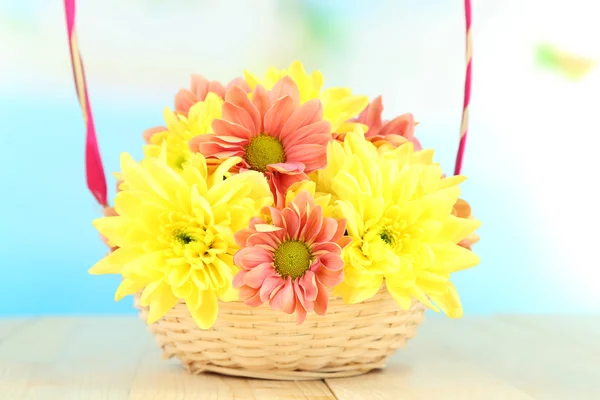 Chrysanthemenblüten im Korb auf Holztisch vor natürlichem Hintergrund — Stockfoto