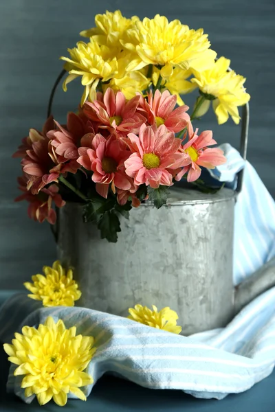 水まき缶と背景の色のファブリックで美しい花の組成 — ストック写真