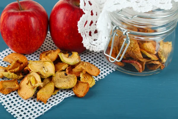 Dried apples in glass jar, on color wooden background — Stock Photo, Image