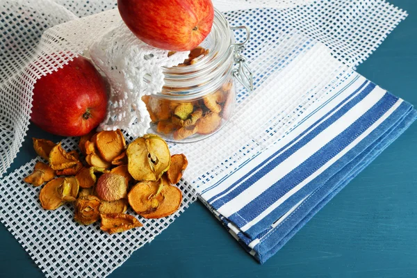 Manzanas secas en tarro de vidrio, sobre fondo de madera de color —  Fotos de Stock