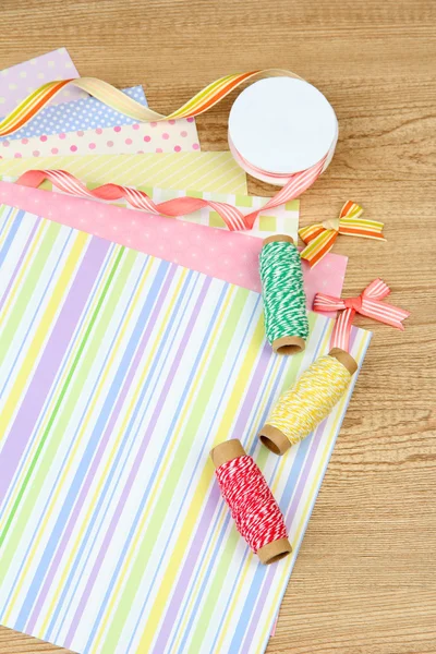 Papier voor scrapbooking en hulpmiddelen voor op houten tafel — Stockfoto