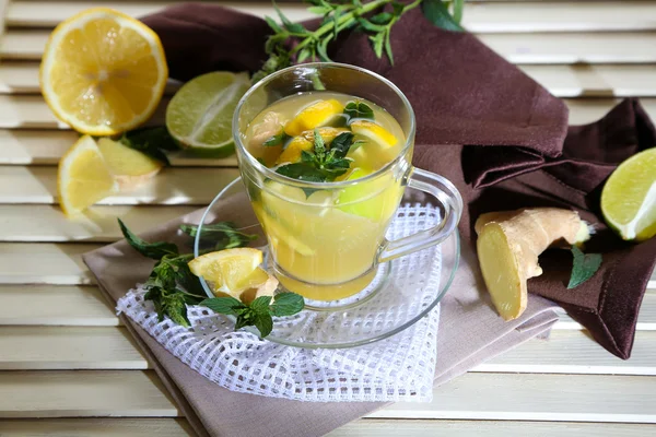 Taza de té con jengibre en servilleta sobre mesa de madera —  Fotos de Stock