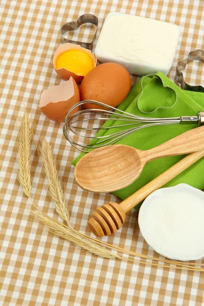 Concepto de cocina. Ingredientes básicos para hornear y herramientas de cocina sobre fondo de mantel — Foto de Stock