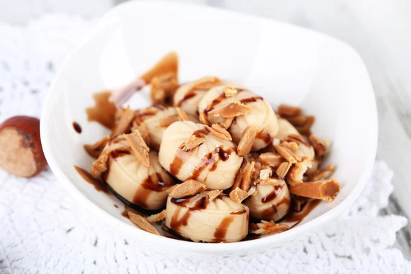 Many toffee in bowl on napkin close-up — Stock Photo, Image