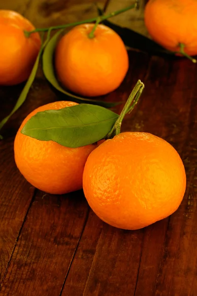 Sweet tangerines with leaves, on wooden background — Stock Photo, Image