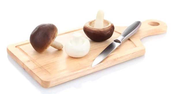 Funghi e coltello su tagliere in legno isolato su bianco — Foto Stock