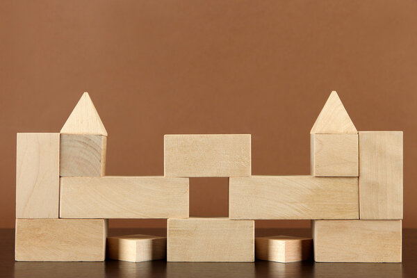 Wooden toy blocks on table on brown background