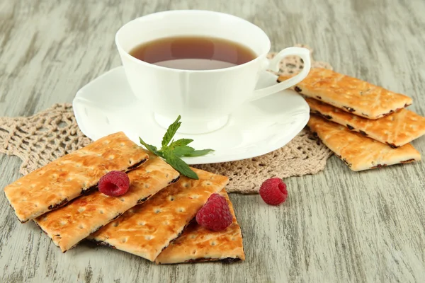 Taza de té con galletas y frambuesas en primer plano de la mesa —  Fotos de Stock