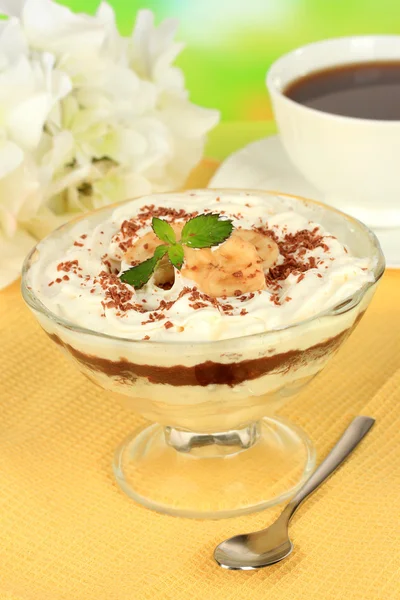 Delicioso postre con plátano y caramelo en la mesa sobre fondo brillante — Foto de Stock