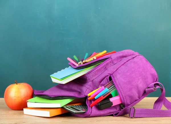 Backpack with school supplies on table — Stock Photo, Image