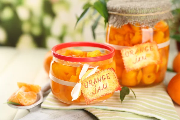 Engarrafamento de laranja com raspas e tangerinas, sobre mesa de madeira branca — Fotografia de Stock