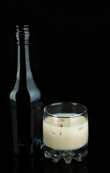 Baileys liqueur in bottle and glass isolated on black — Stock Photo, Image