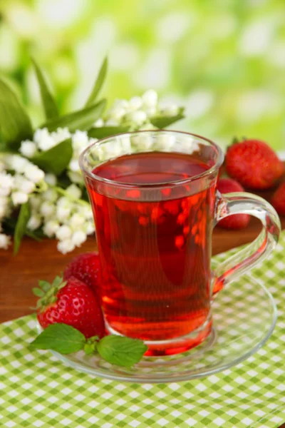 Delicious strawberry tea on table on bright background — Stock Photo, Image