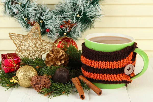 Tazza di cioccolata calda con cioccolatini e addobbi natalizi su tavola su fondo di legno — Foto Stock