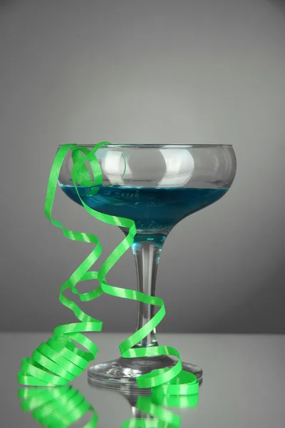 Glas cocktail en streamer afterparty op grijze achtergrond — Stockfoto