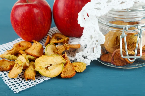 Dried apples in glass jar, on color wooden background — Stock Photo, Image