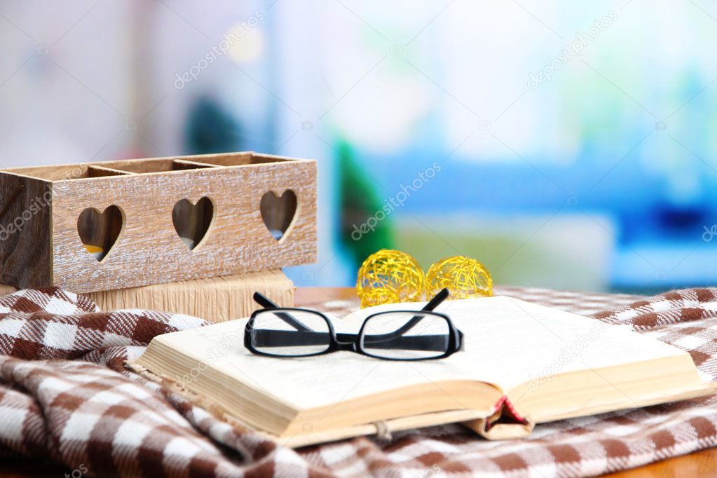 Old book, eye glasses, candles, and plaid
