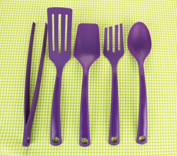 Plastic kitchen utensils on fabric background — Stock Photo, Image