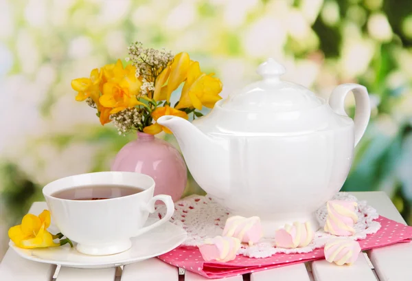 Conjunto bonito com chá na mesa de piquenique de madeira no fundo natural — Fotografia de Stock