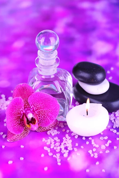 Spa oil with orchid on purple background — Stock Photo, Image