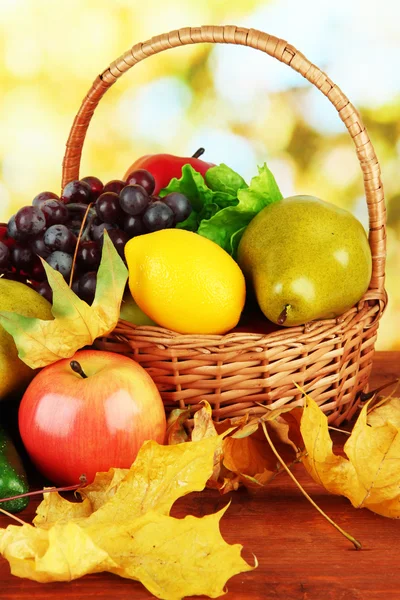 Fruits and vegetables with yellow leaves in basket — Stock Photo, Image