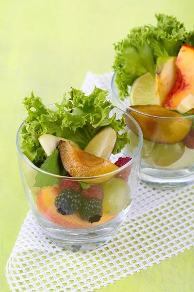 Salada de frutas em copos, no fundo de madeira — Fotografia de Stock