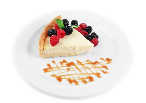 Slice of cheesecake with berries and sauce on plate, isolated on white — Stock Photo, Image