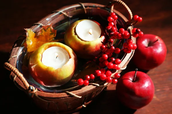 Composition avec pommes et bougies dans le panier sur fond en bois — Photo