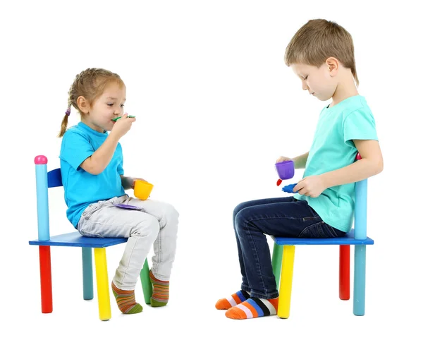 Little children playing with colorful tableware isolated on white — Stock Photo, Image