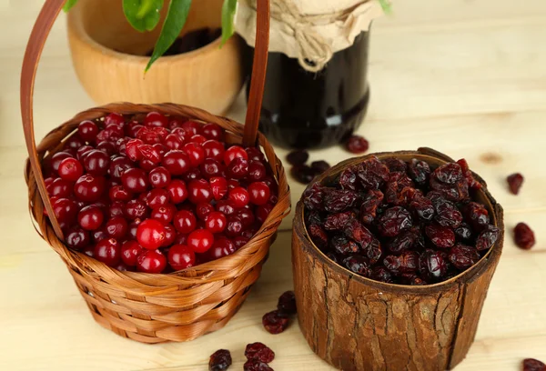 Cranberry fresco e seco em cestas na mesa de madeira — Fotografia de Stock