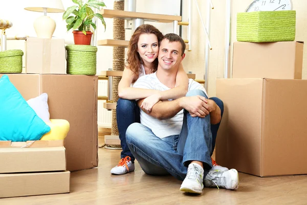 Young couple sitting in new house on staircase background — Stock Photo, Image