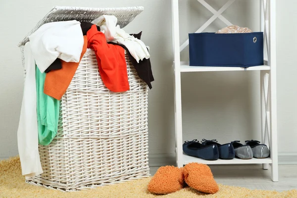 Cesta de lavandería completa en piso de madera en el fondo interior del hogar — Foto de Stock